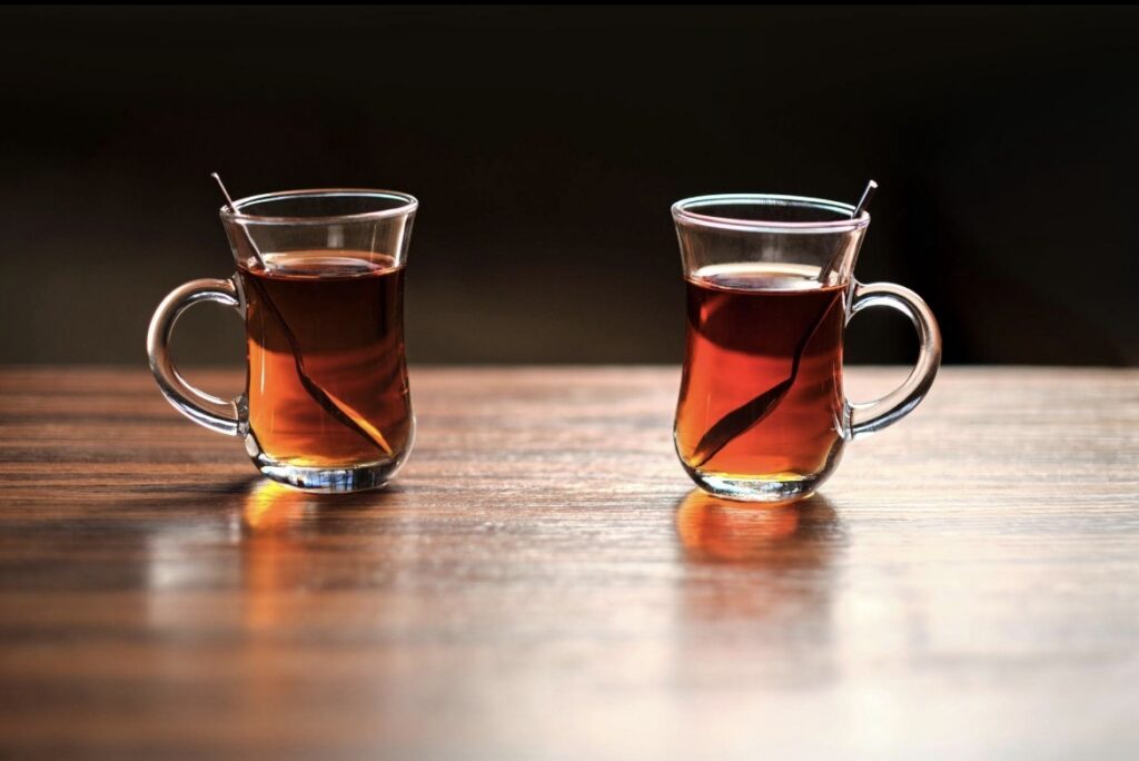 Ahşap masada yan yana duran iki bardak çay.